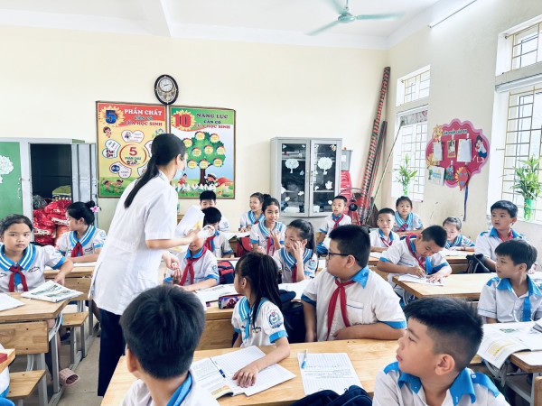 Cán bộ y tế đang tẩy giun cho các cháu học sinh tiểu học